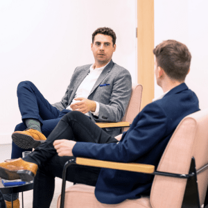 Man sitting on bench with suit on smiling mentoring