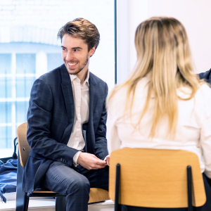 Colleagues socialising, man smiling in suit